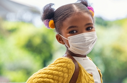 Child outside wearing a facemask